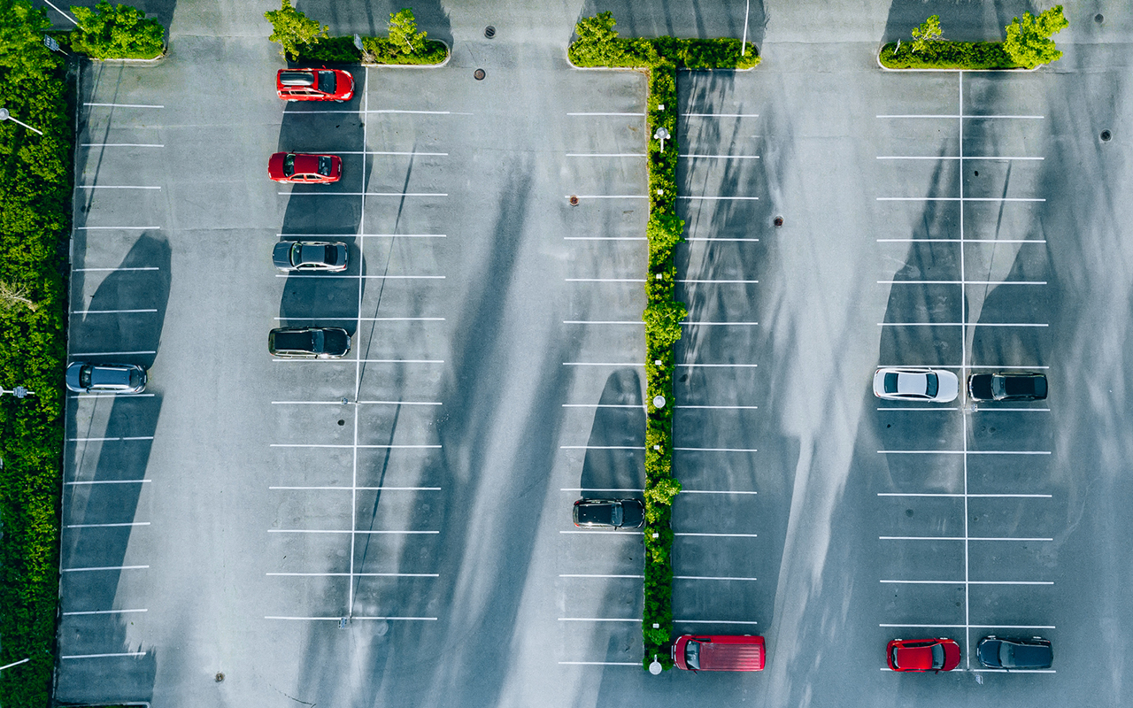 Ilmakuva parkkipaikasta, jolla muutama auto.