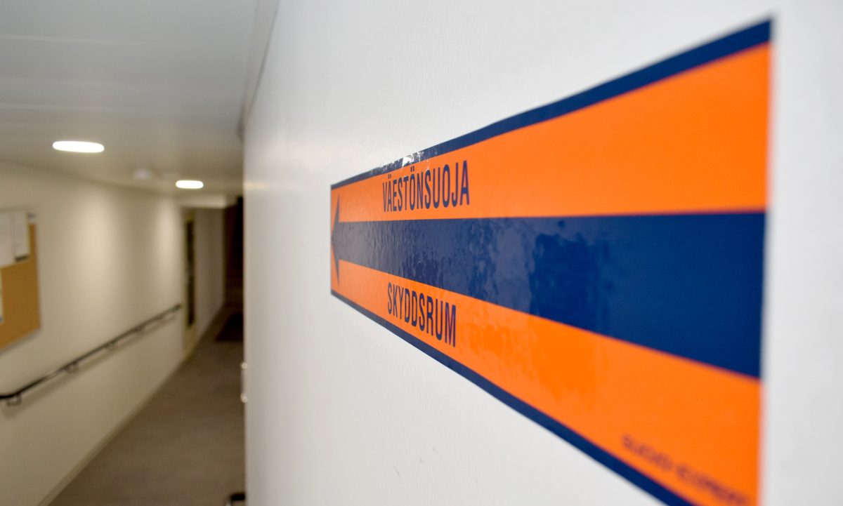 väestönsuojasta kertova kyltti kerrostalon käytävässä