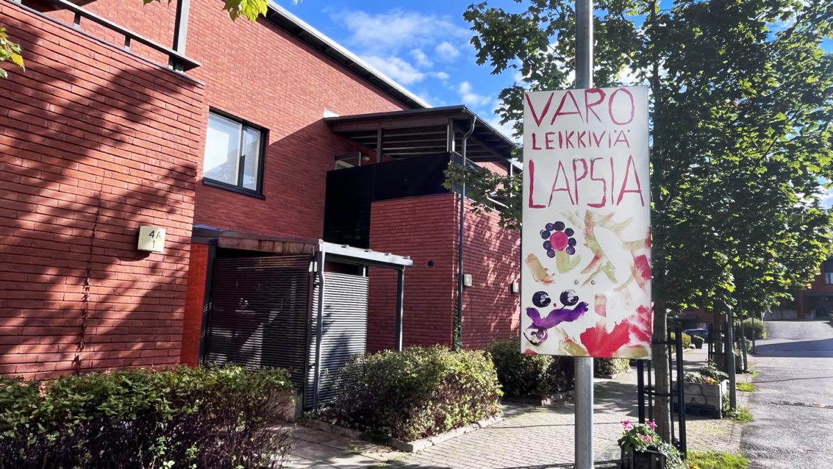 Lasten tekemä värikäs liikennemerkki, jossa lukee: varo leikkiviä lapsia.